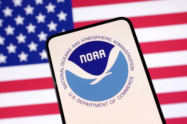 United States National Oceanic and Atmospheric Administration (NOAA) logo and U.S. flag are seen in this illustration taken April 23, 2025. REUTERS/Dado Ruvic/Illustration/File Photo