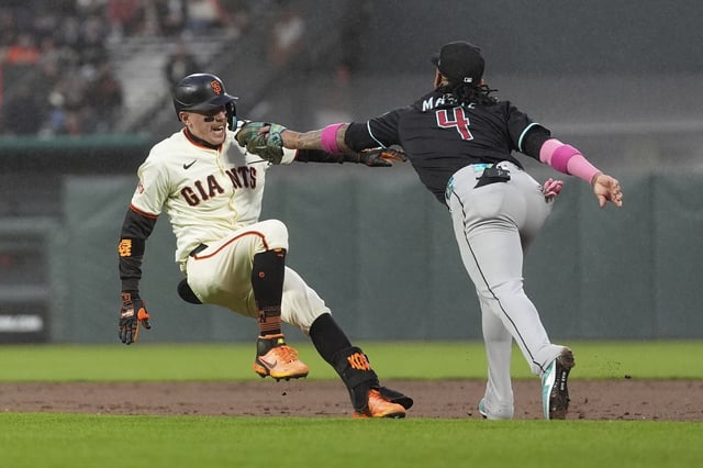 Arizona Diamondbacks second baseman Ketel Marte (4) reaches to tag out San Francisco Giants' Christian Koss after Koss hit an RBI single during the fifth inning of a baseball game in San Francisco, Monday, May 12, 2025. (AP Photo/Jeff Chiu)