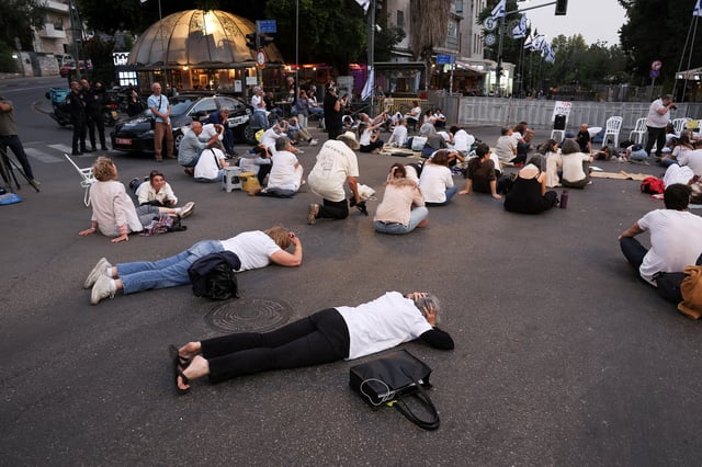 People lie on the floor as they take cover, while sirens sound in Jerusalem, May 13, 2025. Israel’s military reported that a missile was launched from Yemen towards Israel and was intercepted. REUTERS/Ronen Zvulun