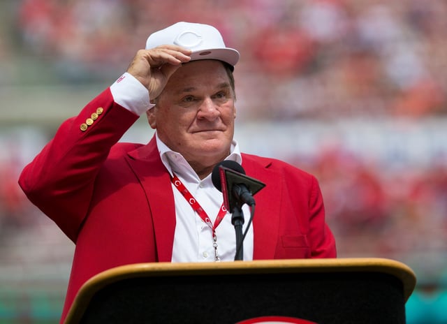 An emotional Cincinnati Reds hall of famer Pete Rose adjusts his cap as he takes the microphone during a pregame ceremony for the unveiling of Pete Rose's bronze statue.