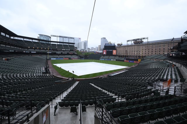 The tarp covers the infield as the baseball game between the Baltimore Orioles and Minnesota Twins was postponed due to weather, Tuesday, May 13, 2025, in Baltimore, and will be made up as part of a doubleheader Wednesday. (AP Photo/Nick Wass)