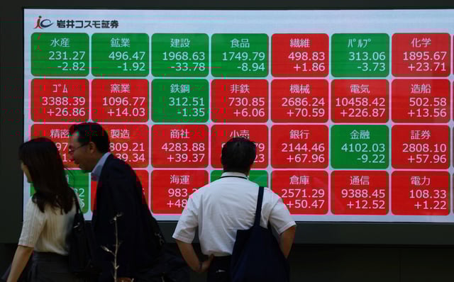 A man looks at an electronic board displaying sector performances related to Nikkei index outside a brokerage in Tokyo, Japan, May 13, 2025.   REUTERS/Kim Kyung-Hoon