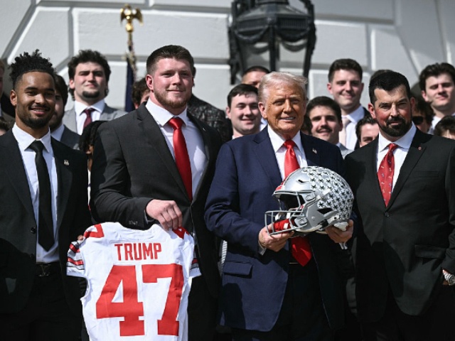 US President Donald Trump, alongside defensive end Jack Sawyer (2nd L), wide receiever Emeka Egbuka (L), and head coach Ryan Day (R), holds an Ohio State Buckeyes football helmet as he hosts the 2025 College Football National Champions, Ohio State Buckeyes, celebrating the team's title-winning season with a ceremony on the South Lawn of the White House in Washington, DC, April 14, 2025. (Photo by Brendan SMIALOWSKI / AFP)