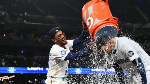 Seattle’s Julio Rodriguez dumps the water jug on teammate J.P. Crawford after defeating the Yankees 2-1 on Tuesday night.