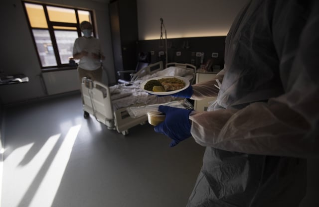 FILE - A Belgian Army medic brings lunch to a patient with COVID-19 at the St. Michiel Hospital in Brussels, Tuesday, Nov. 24, 2020. (AP Photo/Virginia Mayo, File)