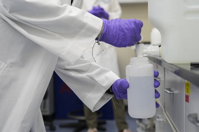 FILE - Logan Feeney pours a water sample with forever chemicals, known as PFAS, into a container for research, April 10, 2024, at a U.S. Environmental Protection Agency lab in Cincinnati. (AP Photo/Joshua A. Bickel, File)