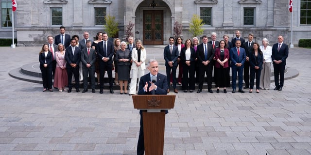 Mark Carney standing in front of his new cabinet on May 13.