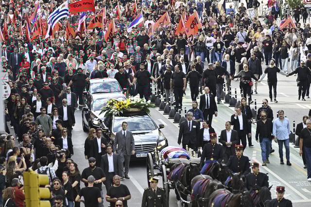 Supporters walk behind the casket of Uruguay's former President Jose Mujica during his funeral procession from the presidential palace to the National Assembly in Montevideo, Uruguay, Wednesday, May 14, 2025. (AP Photo/Santiago Mazzarovich)