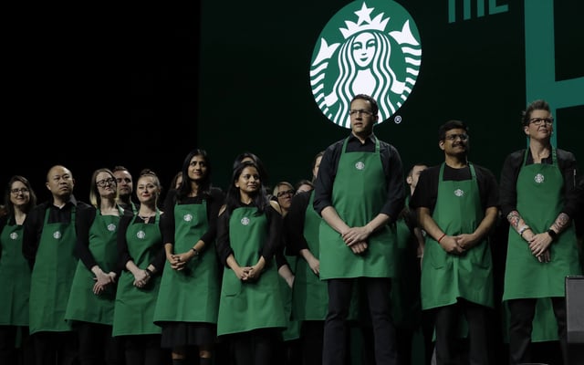 FILE - Starbucks baristas stand on stage, March 20, 2019, during an annual shareholders meeting in Seattle. (AP Photo/Ted S. Warren, file)