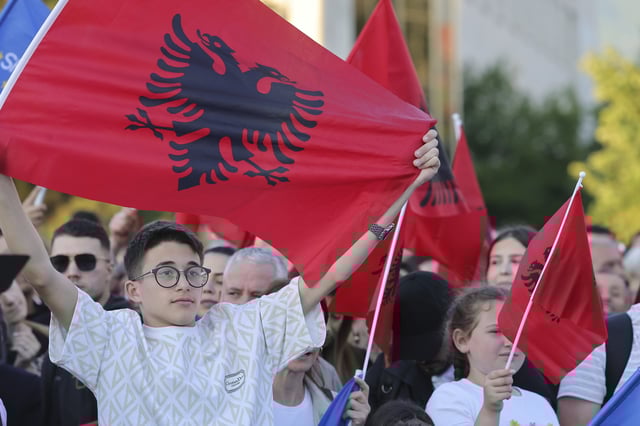 A young boy holds an Albanian flag during a celebratory rally for Albanian Prime Minister Edi Rama's victory in the last parliamentary elections, in Tirana, Albania, Wednesday, May 14, 2025. (AP Photo/Vlasov Sulaj)
