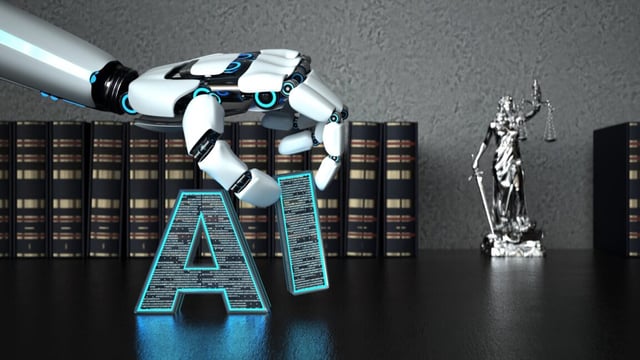 A robot hand places blocks spelling "AI' on a wooden table that also contains law books and a lady justice statue.
