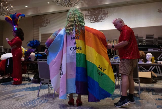 Salem Sanderson wears a cape that reads "Drag is Not a Crime" as she gets dressed backstage during the Miss Gay Days Pageant at the DoubleTree by Hilton Orlando at SeaWorld on June 3, 2023, in Orlando, Florida.