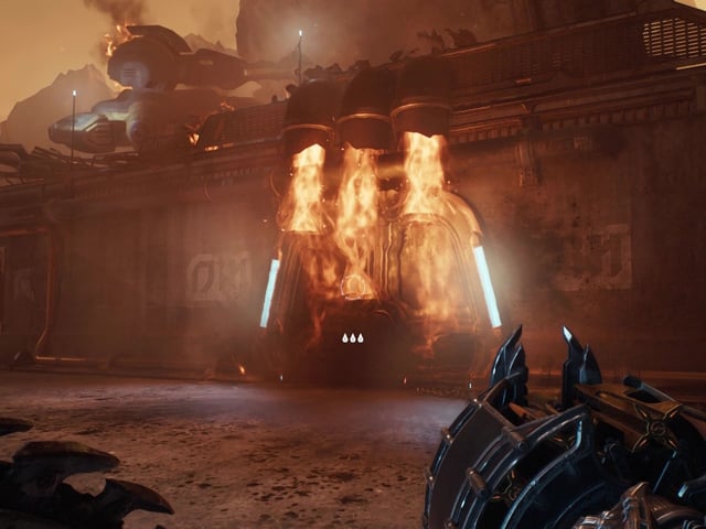 Doom: The Dark Ages fire door - A first-person image of Doom Guy looking at a door blocked by fire, holding a gun and shield at the ready.