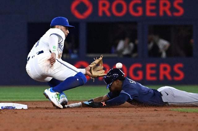 Tampa Bay Rays' left fielder Chandler Simpson, right, is tagged out at second base by Toronto Blue Jays shortstop Bo Bichette (11) on an attempted steal in second inning American League baseball action in Toronto on Wednesday, May 14, 2025. THE CANADIAN PRESS/Jon Blacker