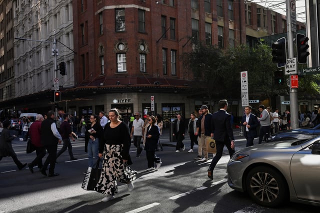 People cross the street in the Sydney Central Business District, in Sydney, Australia, May 14, 2024. REUTERS/Jaimi Joy/File Photo