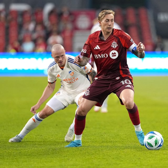 May 14, 2025; Toronto, Ontario, CAN;Toronto FC forward Federico Bernardeschi (10) battles for the ball with FC Cincinnati midfielder Brad Smith (14) during the first half at BMO Field. Mandatory Credit: Nick Turchiaro-Imagn Images