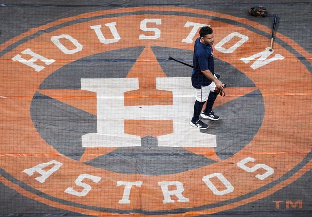 Houston’s Jose Altuve (27) crosses a Houston Astros logo on a tarp before an MLB baseball game at Daikin Park in Houston, Wednesday, May 14, 2025.