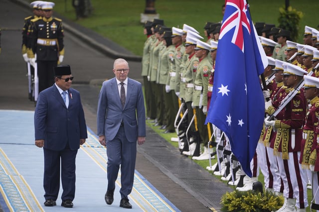Australian Prime Minister Anthony Albanese, center, walks with Indonesian President Prabowo Subianto while inspecting a honor guard before their meeting at Merdeka Palace in Jakarta, Indonesia, Thursday, May 15, 2025. (AP Photo/Dita Alangkara)