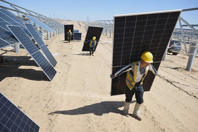 Workers install solar photovoltaic panels in Yinchuan, China. Credit: Cynthia Lee / Alamy Stock Photo