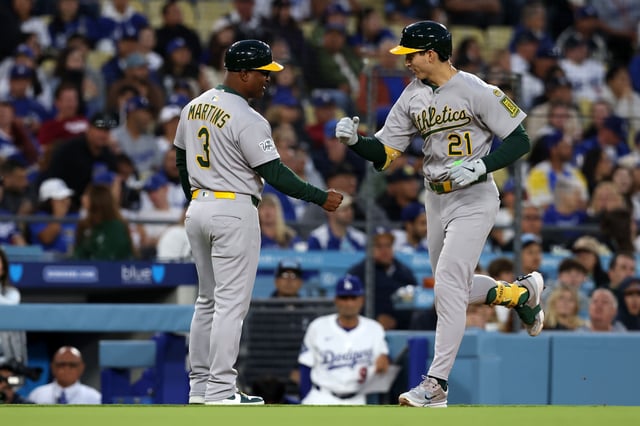 May 14, 2025; Los Angeles, California, USA; Athletics first base Tyler Soderstrom (21) reacts with third base coach Eric Martins (3) after hitting a home run during the third inning at Dodger Stadium. Mandatory Credit: Jason Parkhurst-Imagn Images