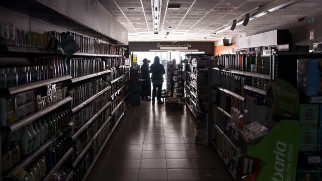 Employees stand inside a supermarket without lights in Burgos on April 28, 2025, during a massive power cut affecting the entire Iberian peninsula and the south of France. A “massive” power cut late on April 28, 2025, affected the whole of the Iberian peninsula and part of France, according to Portuguese electricity network operator REN. (Cesar Manso/AFP/Getty Images/TNS)