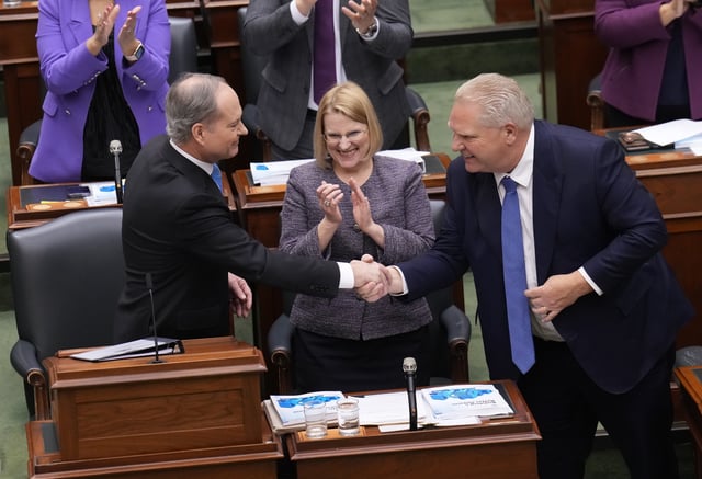 Minister of Finance Peter Bethlenfalvy, left, shakes hands with Premier Doing Ford, right, as Health Minister Sylvia Jones looks on after Bethlenfalvy tabled the Ontario provincial budget at the legislature at Queen's Park in Toronto on March 26, 2024.