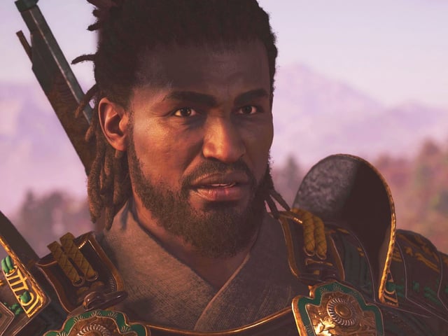 Assassin's Creed Shadows Yasuke unlock - A close-up of Yasuke talking, wearing armour and with a rifle on his back.