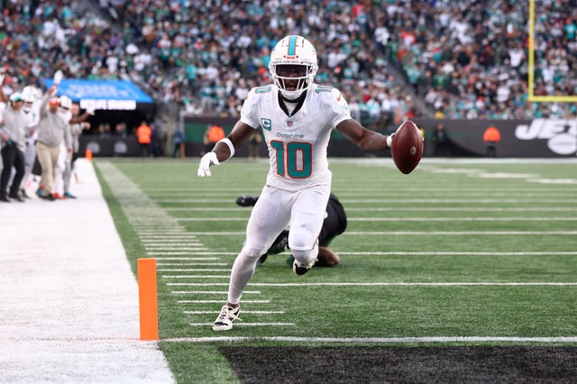 Tyreek Hill #10 of the Miami Dolphins scores a seven yard touchdown pass against the New York Jets during the second quarter in the game at MetLife Stadium on November 24, 2023 in East Rutherford, New Jersey.