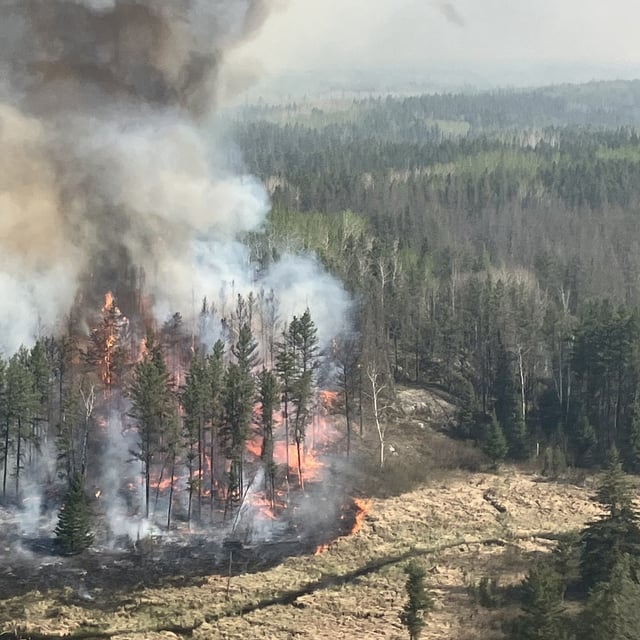 This handout image courtesy Manitoba Government shows a wildfire burning near Lac-du-Bonnet on May 14, 2025 in Manitoba, a province in central Canada experiencing unusually hot, dry and windy conditions. Two people died after being trapped by the wildfire in the rural municipality of Lac du Bonnet. (Photo by Handourt / Manitoba Government / AFP) / RESTRICTED TO EDITORIAL USE - MANDATORY CREDIT "AFP PHOTO /  Manitoba Government/ HO- HANDOUT - NO MARKETING NO ADVERTISING CAMPAIGNS - DISTRIBUTED AS A SERVICE TO CLIENTS (Photo by HANDOURT/Manitoba Government/AFP via Getty Images)