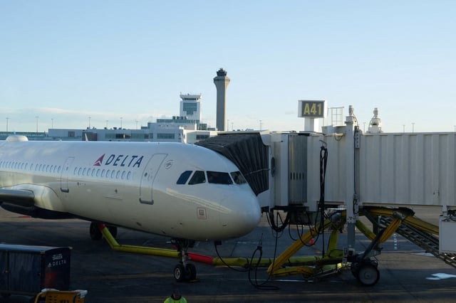 The air traffic control tower is seen from the Denver International Airport terminal, as a Delta flight sits at the gate, in Denver, Colorado, U.S., May 15, 2025.  REUTERS/Megan Varner