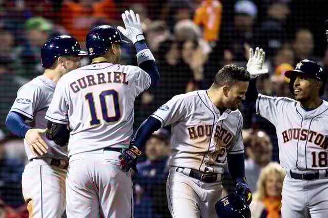 BOSTON, MA - OCTOBER 13: Yuli Gurriel #10 of the Houston Astros reacts with Alex Bregman #10, Jose Altuve #27, and Tony Kemp #18 after hitting a three run home run during the ninth inning of game one of the American League Championship Series against the Boston Red Sox on October 13, 2018 at Fenway Park in Boston, Massachusetts.
