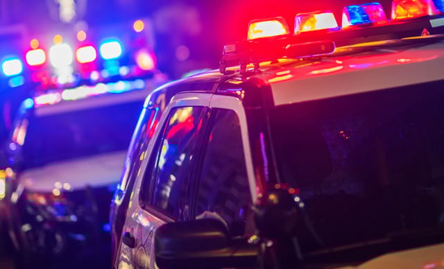 FILE: Police vehicles with flashing lights.