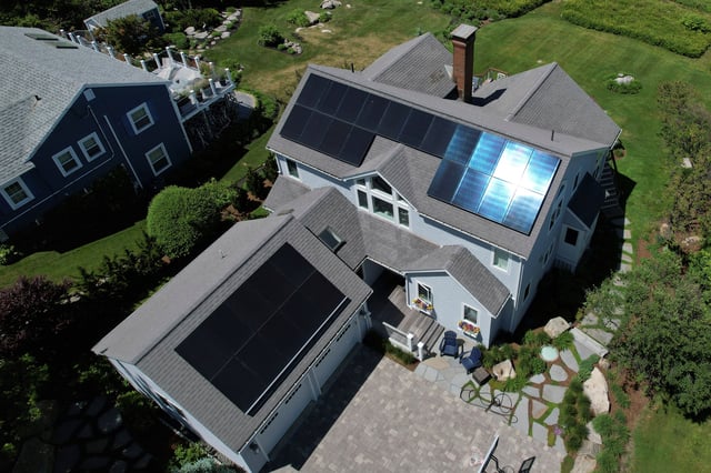 Solar panels create electricity on the roof of a house in Rockport, Massachusetts, U.S., June 6, 2022. Picture taken with a drone. REUTERS/Brian Snyder/ File Photo
