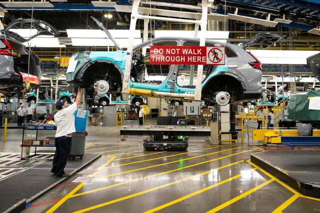 Workers continue vehicle assembly shortly before the line was shut down for an event at the Honda of Canada Manufacturing Plant 2 in Alliston, Ontario, on April 25, 2024 where it was announced that Japanese automaker Honda will make the largest automotive investment in Canada's history worth Can$15 billion (US$11 billion) electric vehicle investment in Ontario that will see four new manufacturing plants built in the province. (Photo by Peter Power / AFP)