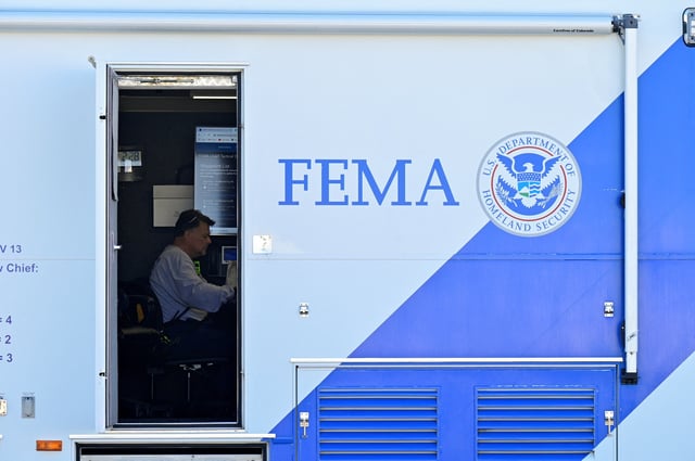 A person sits at a desk inside of a mobile FEMA command center after tornadoes ripped through several U.S. states in downtown Dawson Springs, Kentucky, U.S., December 14, 2021. REUTERS/Jon Cherry/File Photo