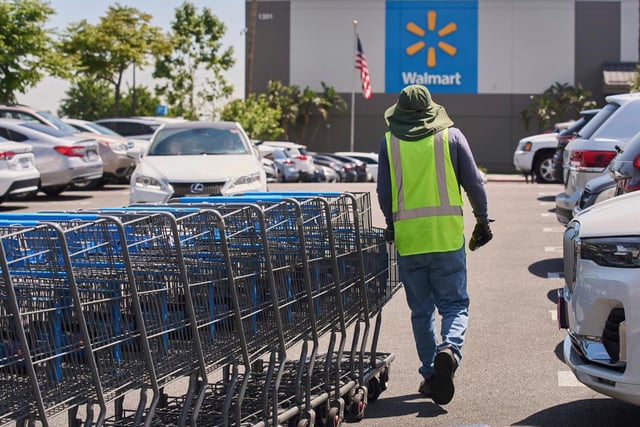 FILE – Empty shopping carts are collected from the parking lot at Walmart store in Burbank, Calif., on Thursday, April 10, 2025. (AP Photo/Damian Dovarganes, File)