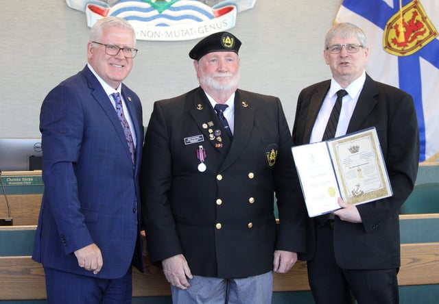 Ben Haighway of Reserve Mines, centre, a Cape Breton Division Representative for the Navy League of Canada, accepts a King Charles III Coronation Medal presented to him by Cape Breton Regional Municipality Mayor Cecil Clarke, left, and CBRM District 9 Coun. David MacKeigan ahead of a May 13 council meeting at city hall in Sydney.