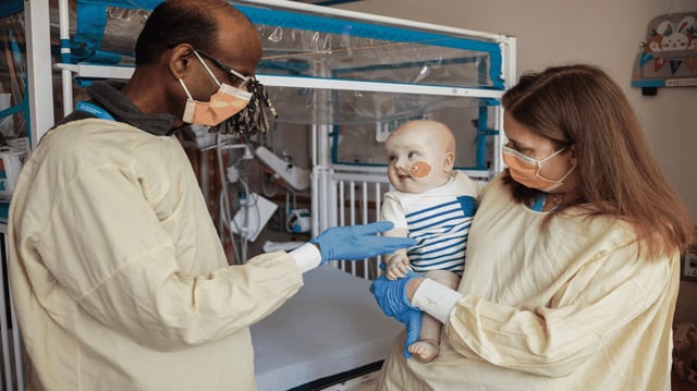 Penn Medicine's Kiran Musunuru (left) and Rebecca Ahrens-Nicklas (right) visiting KJ at Children's Hospital of Philadelphia. Photo: Children's Hospital of Philadelphia via Penn Medicine News