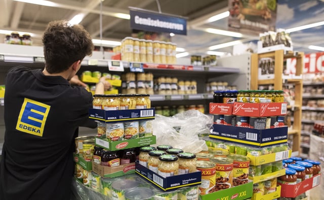 Ein Mitarbeiter von Edeka füllt ein Regal auf. (Archivfoto)