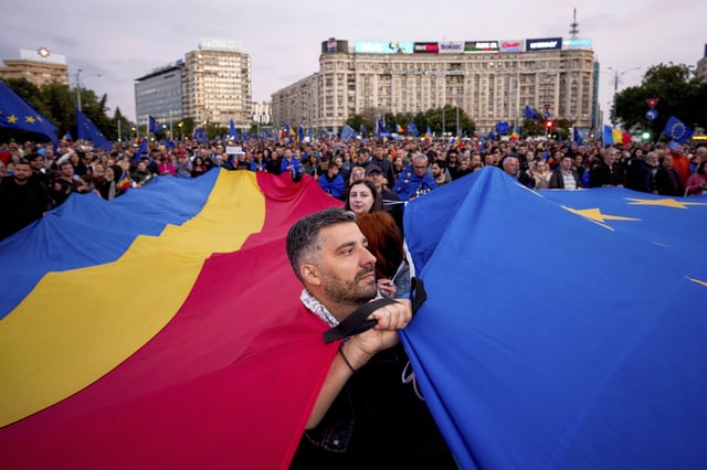 FILE - Demonstrators hold large Romanian and European Union flags during a pro-EU rally ahead of the second round of the presidential election redo in Bucharest, Romania, Friday, May 9, 2025. (AP Photo/Andreea Alexandru, File)