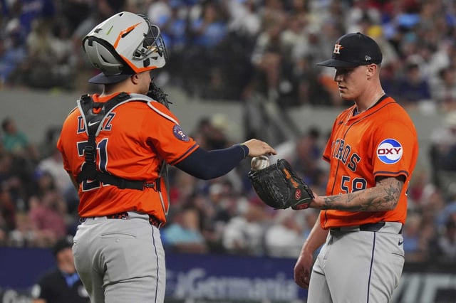 Houston Astros catcher Yainer Diaz (21) hands the game ball to starting pitcher Hunter Brown (58) during the ninth inning of a baseball game against the Texas Rangers, Thursday, May 15, 2025, in Arlington, Texas. (AP Photo/LM Otero)
