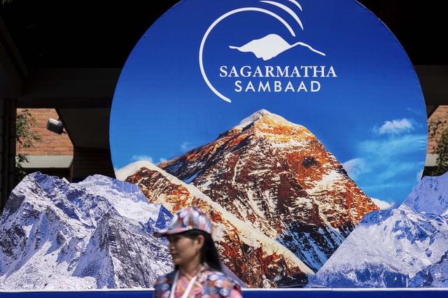 A volunteer awaits to welcome delegates during the inauguration of an environment conference named Sagarmatha Sambaad (Mount Everest Dialogue) at the Soaltee Hotel in Kathmandu, Nepal, Friday, May 16, 2025. (AP Photo/Niranjan Shrestha)estha)