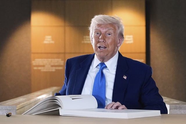 President Donald Trump signs the guest book after touring the Abrahamic Family House, Friday, May 16, 2025, in Abu Dhabi, United Arab Emirates.