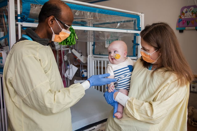 Baby KJ is held by one of his doctors, Rebecca Ahrens-Nicklas of the Children's Hospital of Philadelphia, as Kiran Musunuru of the University of Pennsylvania looks on.