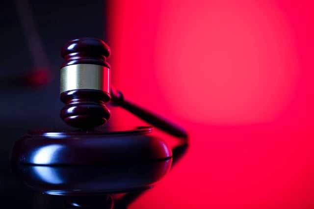 Judge's gavel over red and black background