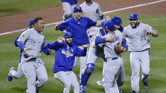 The Kansas City Royals swarm relief pitcher Wade Davis to celebrate after defeating the New York Mets 7-2 to win the World Series on Sunday, November 1, 2015, at Citi Field in New York.
