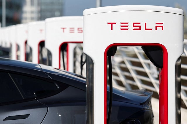 The logo of Tesla is pictured at a Tesla Super Charging station in Saint-Herblain near Nantes, France, March 27, 2025. REUTERS/Stephane Mahe/File Photo