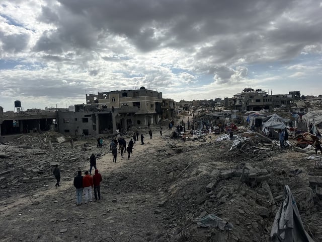 Palestinos inspeccionan el lugar de un ataque israelí contra tiendas de campaña y edificios que albergan a personas desplazadas.