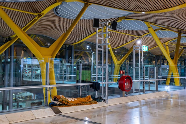 Una persona duerme en el Aeropuerto de Barajas. EFE/Fernando Villar