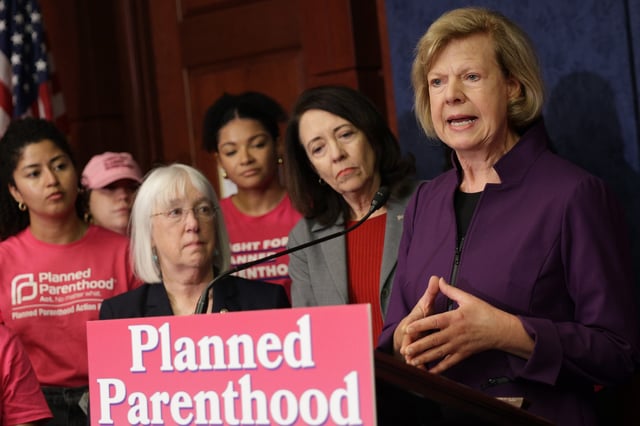 U.S. Sen. Tammy Baldwin (D-WI) speaks as Sen. Patty Murray (D-WA) (4th R) and Sen. Maria Cantwell (D-WA) (2nd R) listen during a news conference on the budget reconciliation bill at the U.S. Capitol on May 14, 2025 in Washington, DC.